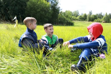 Yazın çimenlerde dinlenen üç kardeş.