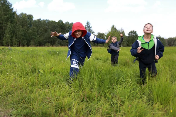 夏に畑を駆け抜ける３人の少年 — ストック写真