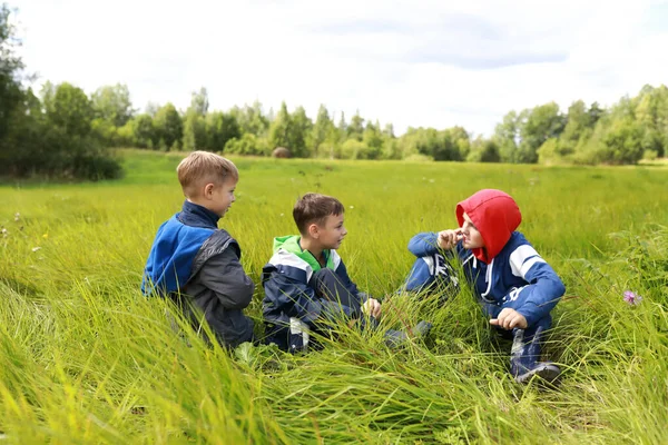 Yazın çimenlerde dinlenen üç çocuk.