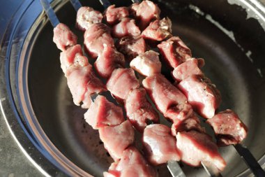 Mutfaktaki şişte çiğ domuz eti.