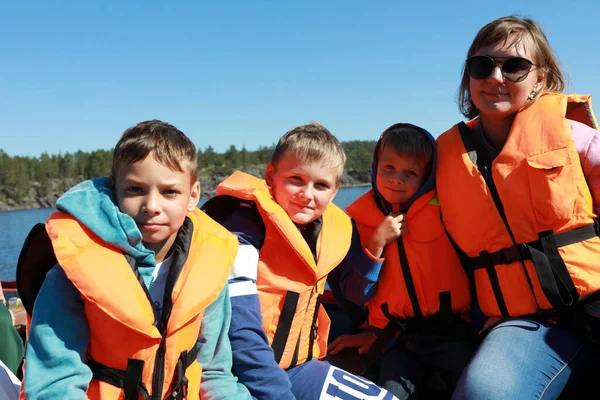 Mother with sons in life jacket on boat in Ladoga skerries