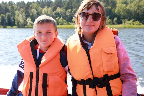 拉多加滑雪场的妈妈和儿子穿着救生衣在船上 — 图库照片