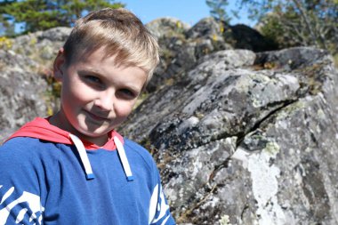 Child on stone island in lake Ladoga skerries, Karelia clipart