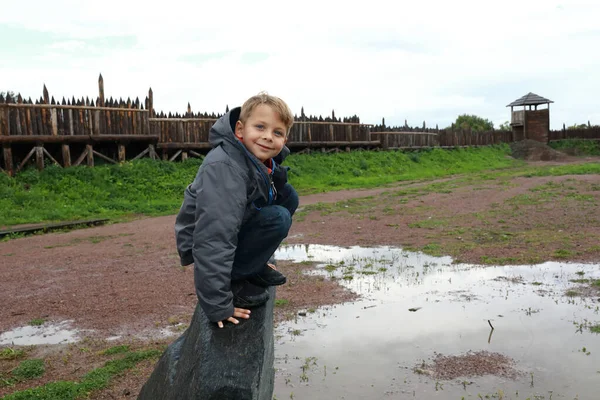 Chłopiec Siedzi Kamieniu Wikingów Wiosce Latem — Zdjęcie stockowe