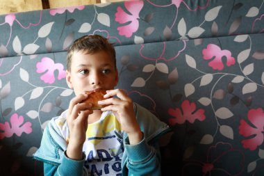 Restoranda turta yiyen bir çocuk.