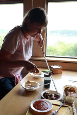 Kadın lokantada şiş etinden et çıkarıyor.