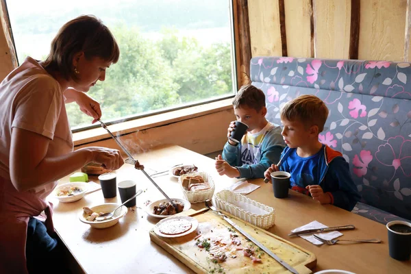 Mãe Remove Carne Espeto Para Dois Filhos Restaurante — Fotografia de Stock