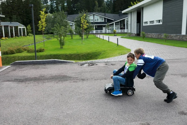 Child Pushes Toy Car Which His Friend Sitting Summer — Stock Photo, Image