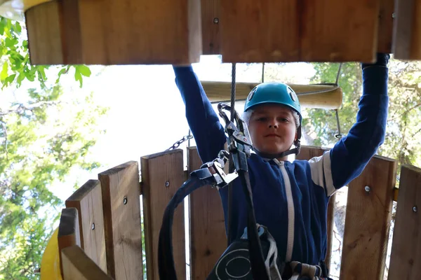 小孩在缆绳冒险园爬过木管 — 图库照片