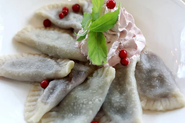 Sweet dumplings with cherries on plate in a restaurant