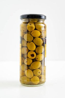 Şişede beyaz bir zemin üzerinde zeytin şişesi ve kırpma yolu. 