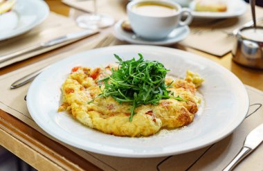 omlet restoranda roka salatası ile