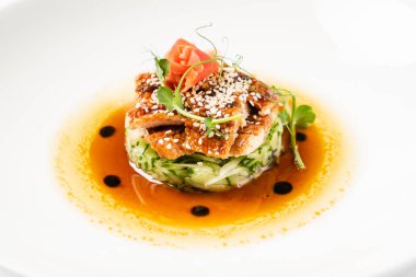 Beyaz tabakta sebze ile kızarmış yılan balığı