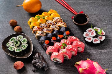 Suşi dürümleri siyah taş üzerine servis edilir. Siyah arka planda. 