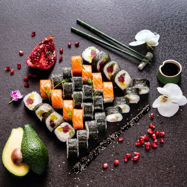 Suşi dürümleri siyah taş üzerine servis edilir. Siyah arka planda. 