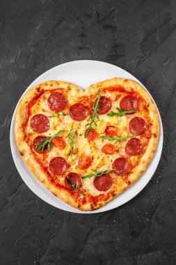 Kalp şeklinde et ve sebzeli pizza. Sevgililer Günü için romantik aşk konsepti. 