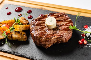 Orta pişmiş ızgara biftek, pirzola ve tereyağı.