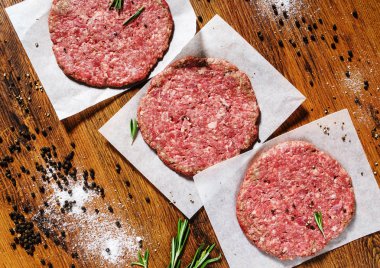 Beşamel sos için rustik ahşap kesme tahtası üzerinde organik sığır eti burger