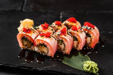 Siyah arkaplanda suşi var.