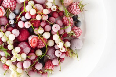 Beyaz tabakta dondurulmuş meyveler