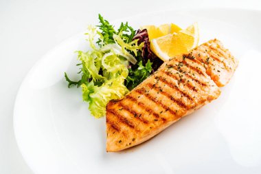 Limon ve taze salata yaprakları ile ızgara somon