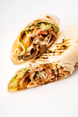 Beyaz arka planda izole edilmiş kızarmış tavuk eti ve sebzeli tortilla dürümü