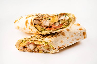 Beyaz arka planda izole edilmiş kızarmış tavuk eti ve sebzeli tortilla dürümü