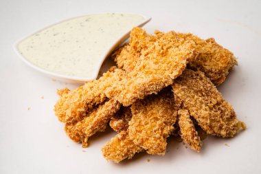 Kızarmış tavuk külçeleri beyaz arka planda izole edilmiş.