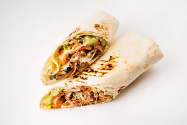 Beyaz arka planda izole edilmiş kızarmış tavuk eti ve sebzeli tortilla dürümü