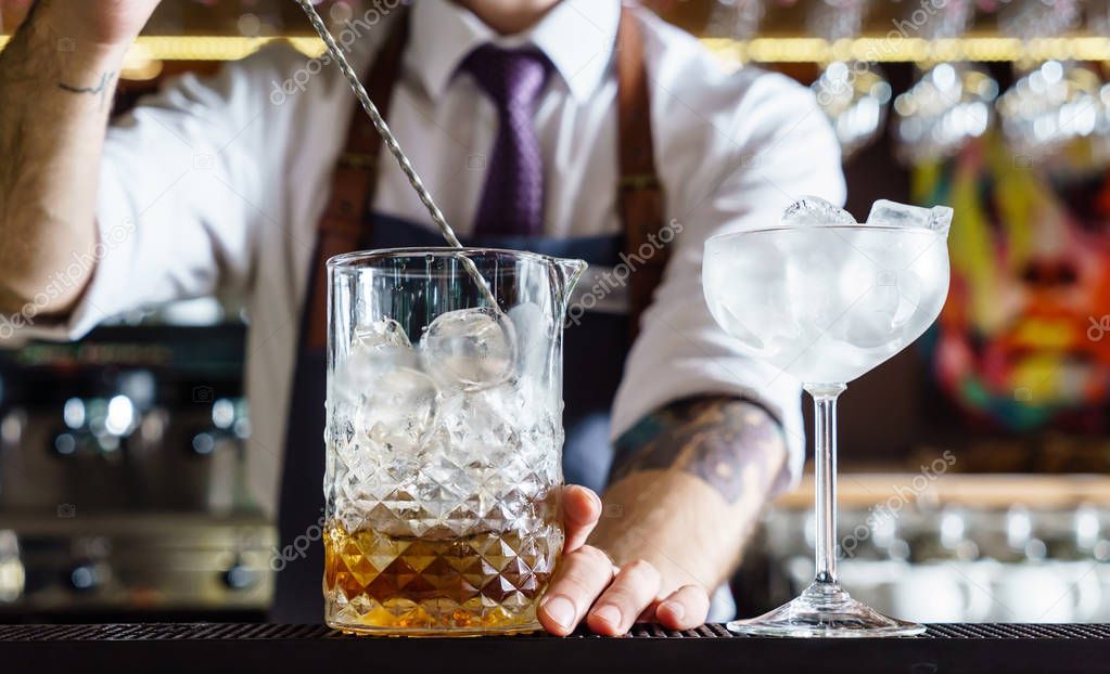 Expert barman is making cocktail at night club