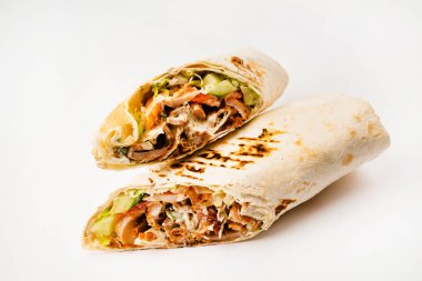 Beyaz arka planda izole edilmiş kızarmış tavuk eti ve sebzeli tortilla dürümü
