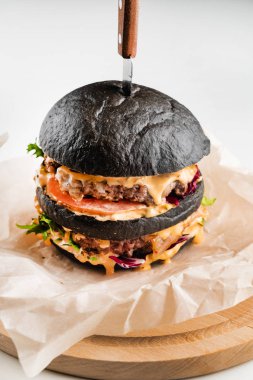 Ahşap arka planda iştah açıcı bir siyah hamburger.
