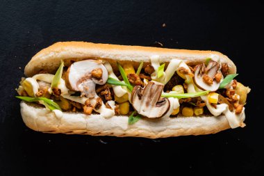 Siyah arka planda sosisli sandviç.