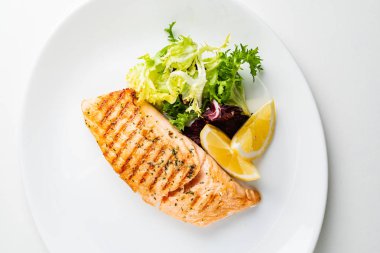 Limon ve taze salata yaprakları ile ızgara somon