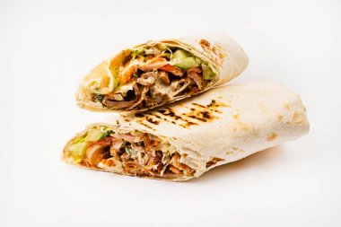 Beyaz arka planda izole edilmiş kızarmış tavuk eti ve sebzeli tortilla dürümü