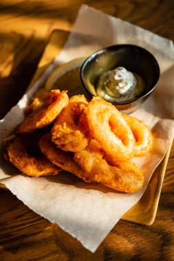 Lezzetli altın hırpalanmış, ekmekli ve kızarmış soğan halkaları.