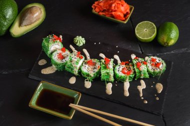 Siyah arkaplanda suşi var.