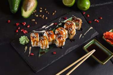 Siyah arkaplanda suşi var.