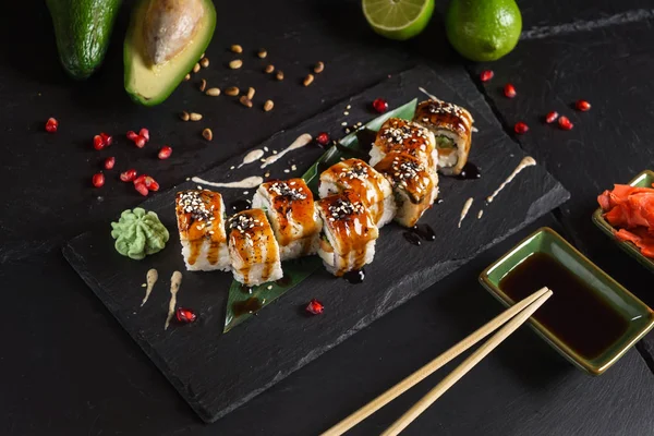 Siyah arkaplanda suşi var.