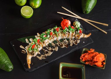 Siyah arkaplanda suşi var.