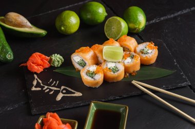 Siyah arkaplanda suşi var.