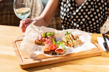 Terasta yaz kahvaltısı yapan bir kadın.