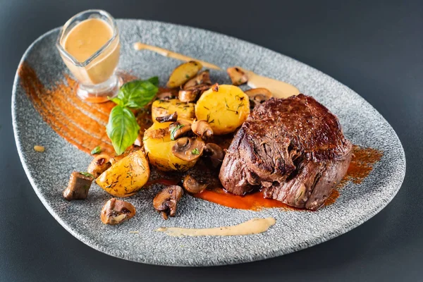 beef steak with sauce and baked potatoes, close up