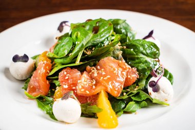plaka üzerinde somon balık ile sezar salatası 