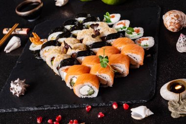 Siyah arkaplanda suşi var.