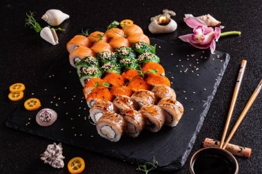 Siyah arkaplanda suşi var.