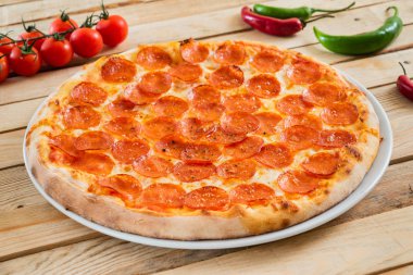 Ahşap arka planda taze pişmiş pepperoni pizza.