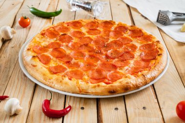 Ahşap arka planda taze pişmiş pepperoni pizza, yakın