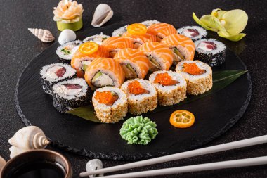 Siyah arkaplanda suşi var.