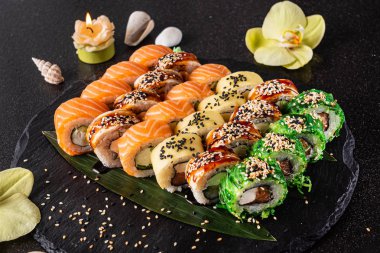 Siyah arkaplanda suşi var.